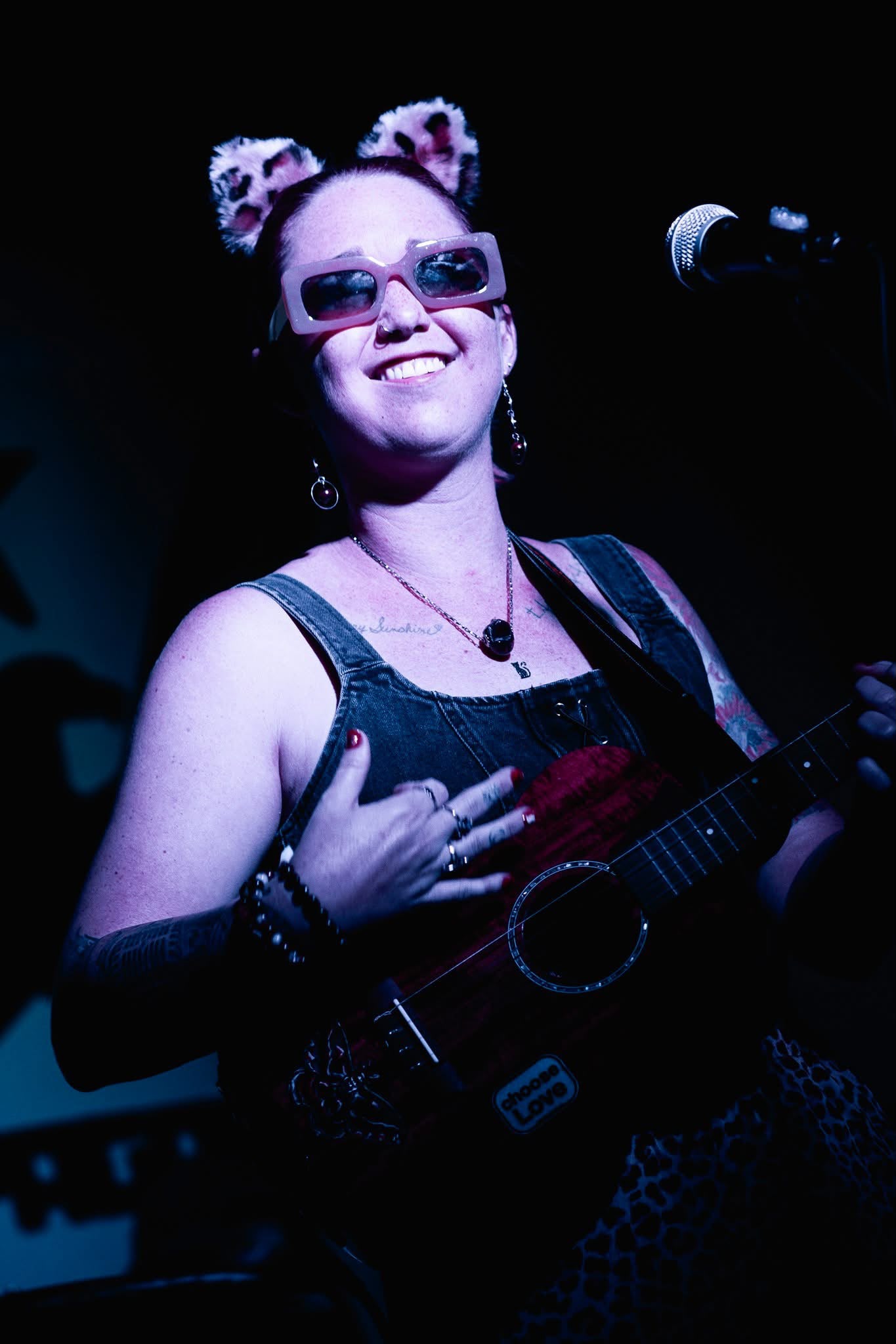 Mad Mellow’s singer playing ukulele in a cat-ear headband under the stage lights