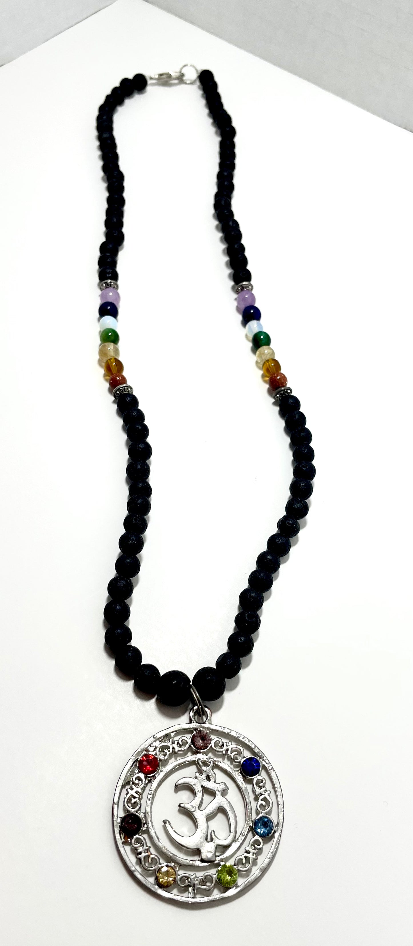 23.5” Stainless Steele Om Chakra Diffuser Necklace Adorned With 6mm Lava Stone Diffuser Beads & Chakra Stones (Amethyst, Lapis Lazuli, Opalite, Green Tigers Eye, Citrine, Amber, & Goldstone)