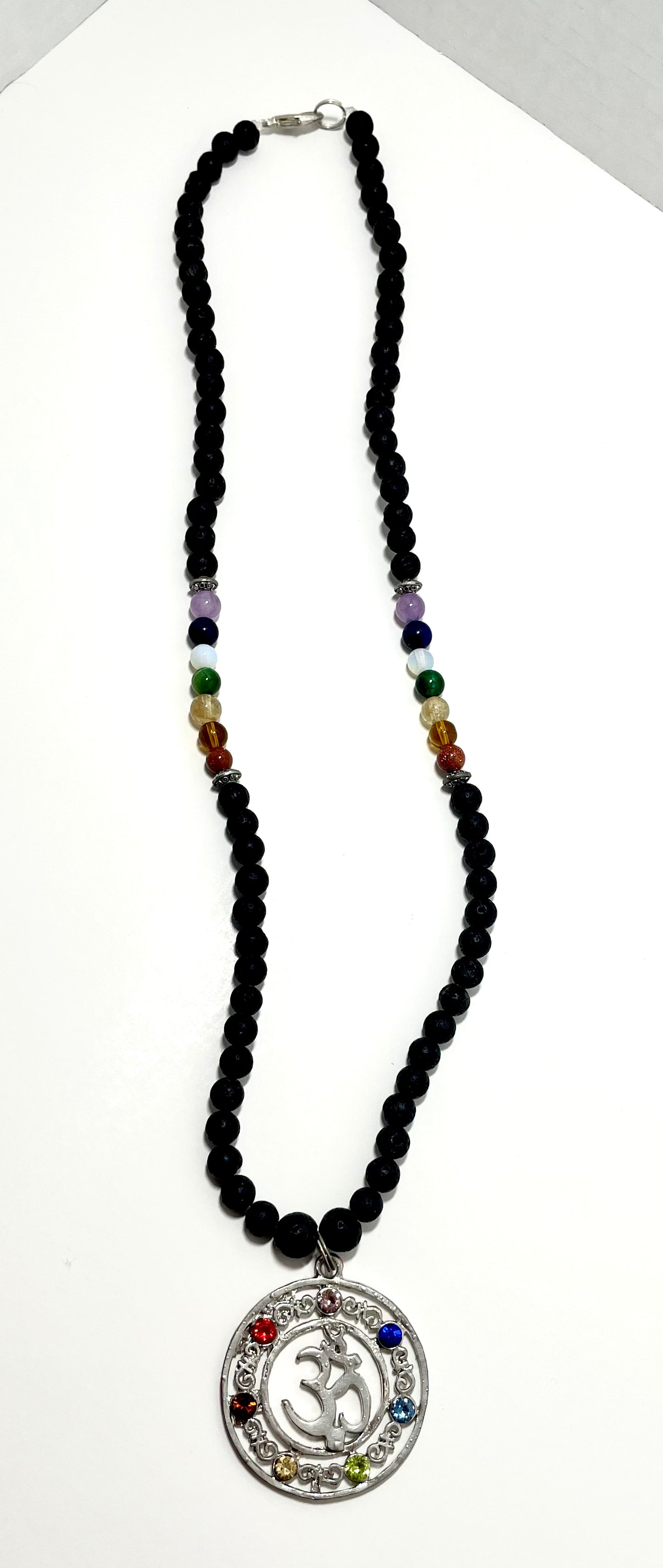 23.5” Stainless Steele Om Chakra Diffuser Necklace Adorned With 6mm Lava Stone Diffuser Beads & Chakra Stones (Amethyst, Lapis Lazuli, Opalite, Green Tigers Eye, Citrine, Amber, & Goldstone)